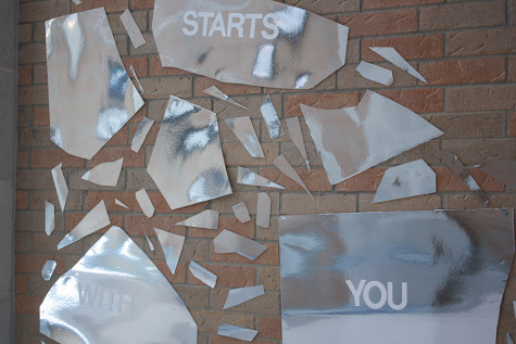 A part of the IB art mural that says "It Starts with You". This part of the mural is reflective.