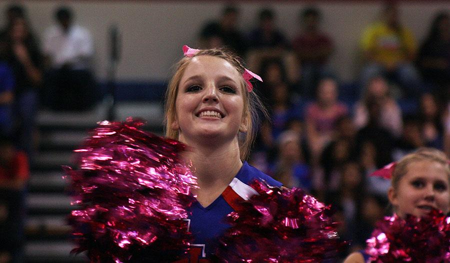 Junior Claire Jenkins cheering on the football team as they enter the pep rally last Friday.