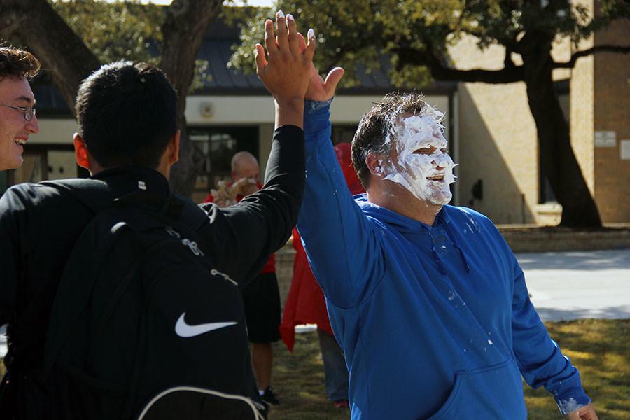 Coach Grissom high fives one of the students that gave him a face full of cream