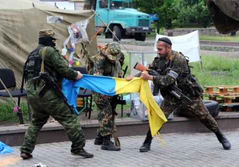 Pro-Russian fighters rip apart a Ukrainian flag outside a regional state building in Donestsk, Ukraine, on May 29, 2014