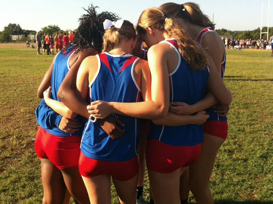 Varsity+girl+members+huddle+at+the+Liberty+Hill+meet+in+preparation+for+what+will+be+another+win+in+their+streak.