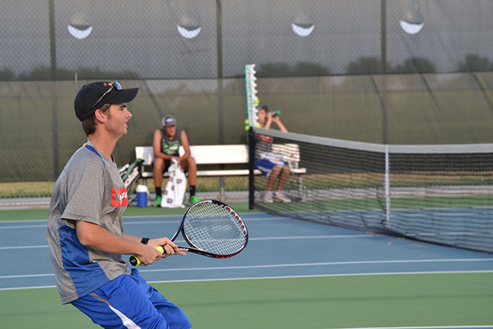 Senior Russell Thomas gripping his tennis racket, preparing for the opposing team to shoot the ball back. They would then lose three consecutive games.