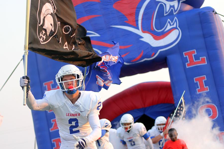 Senior Gabriel Sanchez leading the pride of the Lions out of the tunnel. Sanchez is also carrying the Molon Lobe flag.