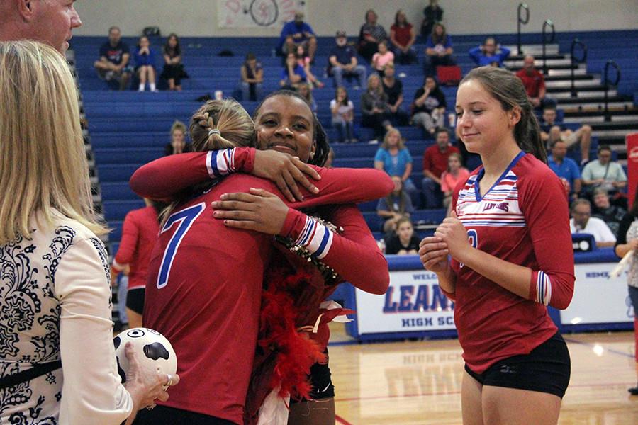 Sophomore Busi Banda sharing a moment with senior Callie Reed. The underclassmen stand on the sidelines while the seniors are being announced and celebrated.