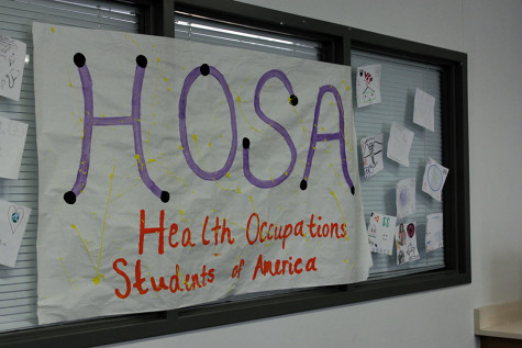 Poster hanging up in Ms.Halls room painted by HOSA. The room behind it is designed to look like a hospital room for students to practice in.