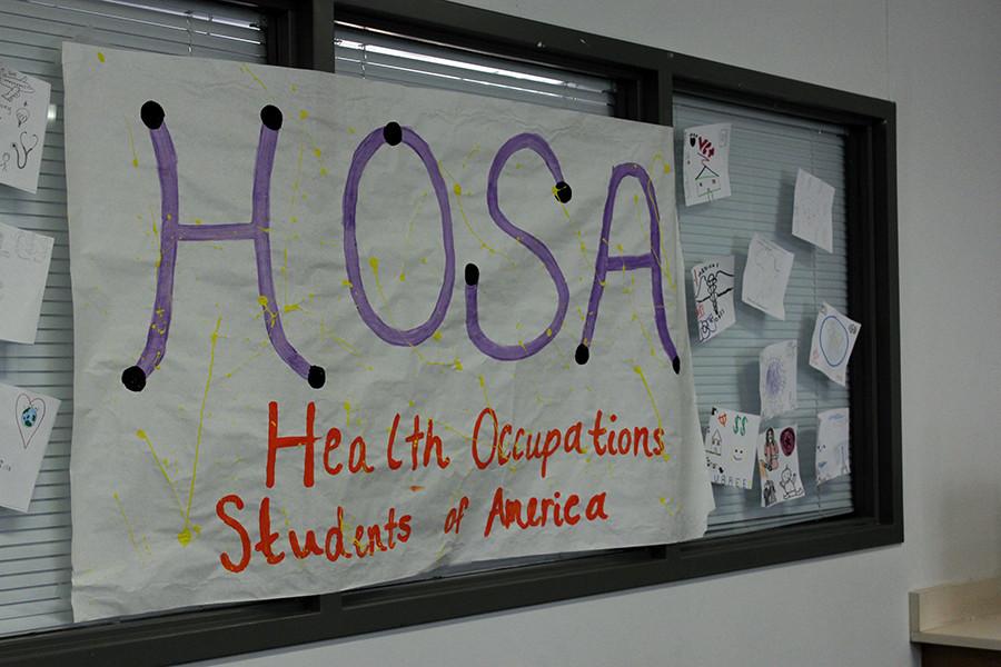 Poster+hanging+up+in+Ms.Halls+room+painted+by+HOSA.+The+room+behind+it+is+designed+to+look+like+a+hospital+room+for+students+to+practice+in.