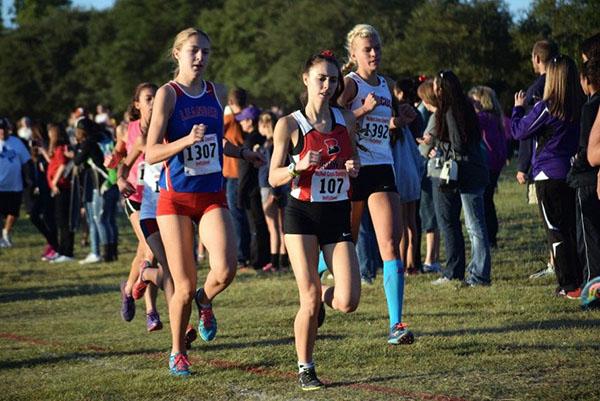 Senior Claire Crone ( left) competes at the McNeil meet. She broke the school record and her own personal record.