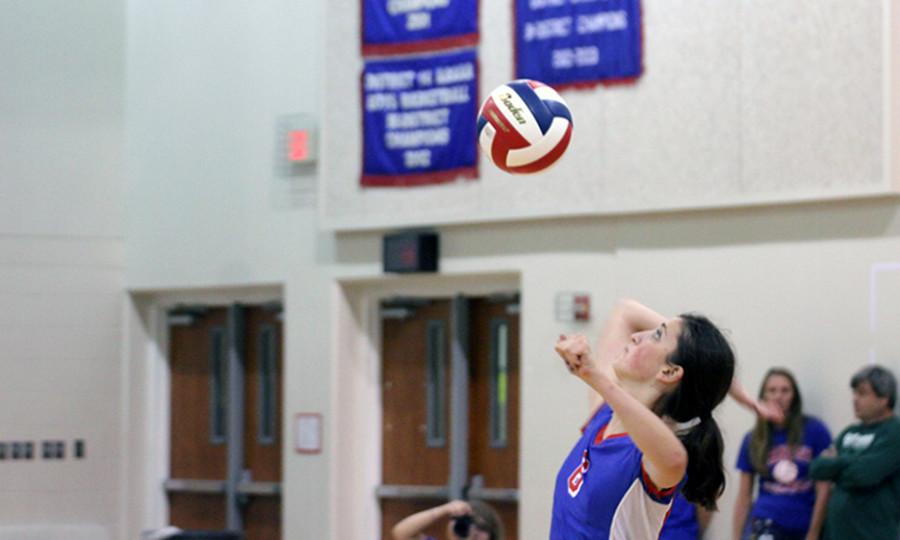 Junior Alyse Balderrama serving the ball during a match. This is a vital moment because the server could miss and a point would go to the opponent.