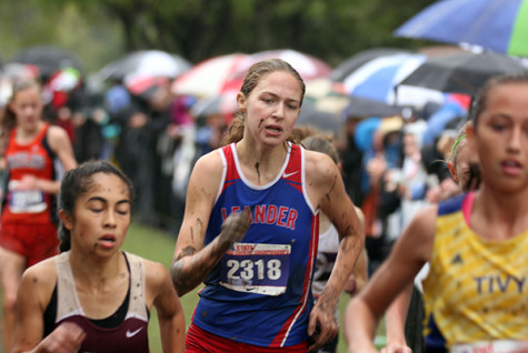 Claire Crone racing to the finish line. She was covered in mud because she had fallen twice during the race, coming out to place 52nd.