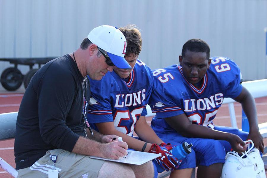 Freshmen Coach Kyle Sturgell reviews plays with members of the Blue team. The single victory on the Blue team's side came from the joint game.