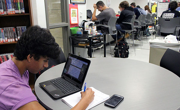 Junior Phillip Megie is using the schools new technology and lap tops to finish his homework. The laptops are set up through mLISD.