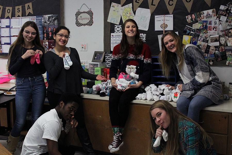 HOSA officers posing with their collected socks. The club collected over 100 pairs of socks.