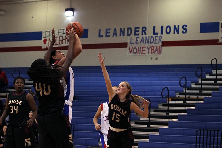 The JV team attempting to make a basket with two rouse girls attempting to block at a previous game versus Rouse. The JV team lost recently to Vista Ridge 31-44.