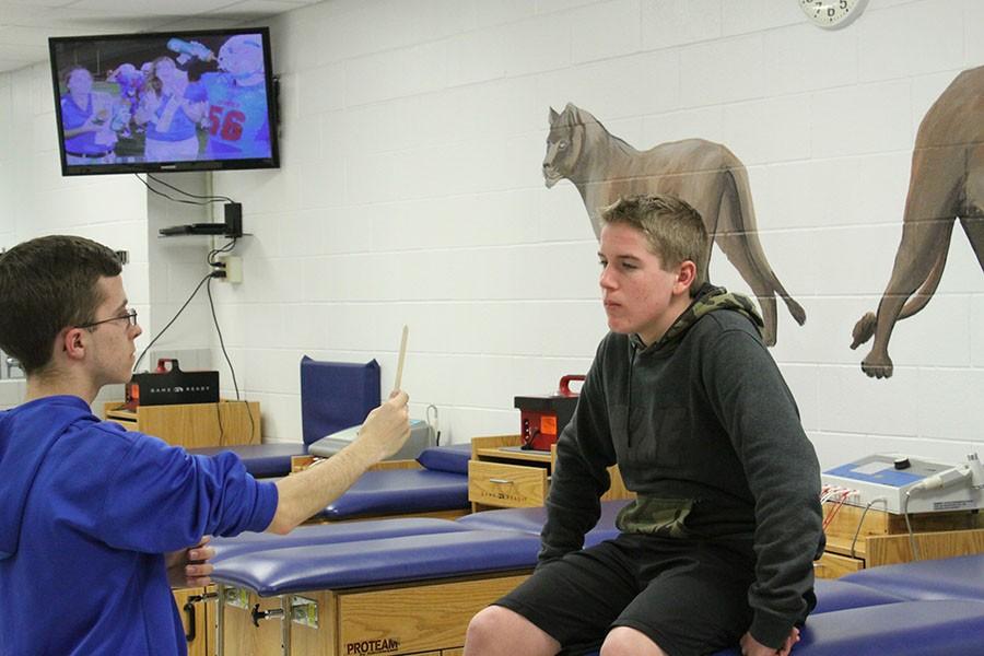  Freshmen Riley Wells and senior Zach Patton demonstrate how to test a concussion. Concussions can cause numerous types of injuries in numerous types of ways. 