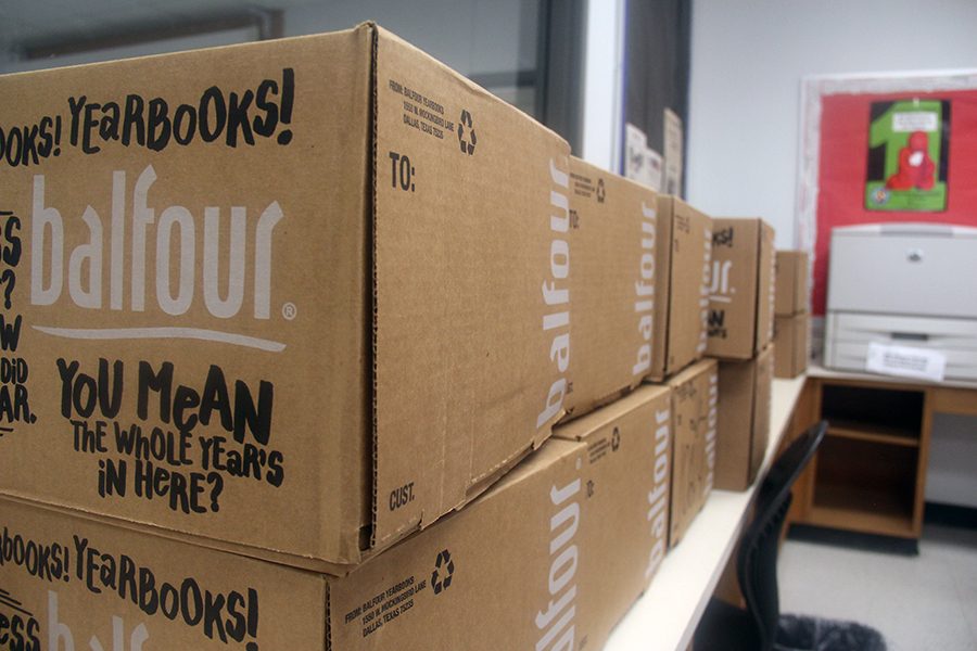 The boxes filled with yearbook in Mrs.Bell's room. The total weight of these boxes is 3,200 lbs.