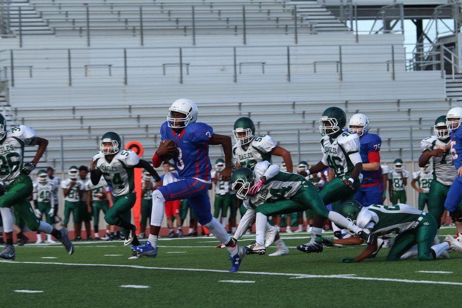 Sophomore quarterback Rashad Carter breaks through the Ellison defense. Carter secured two rushing touchdowns against the Eagles.