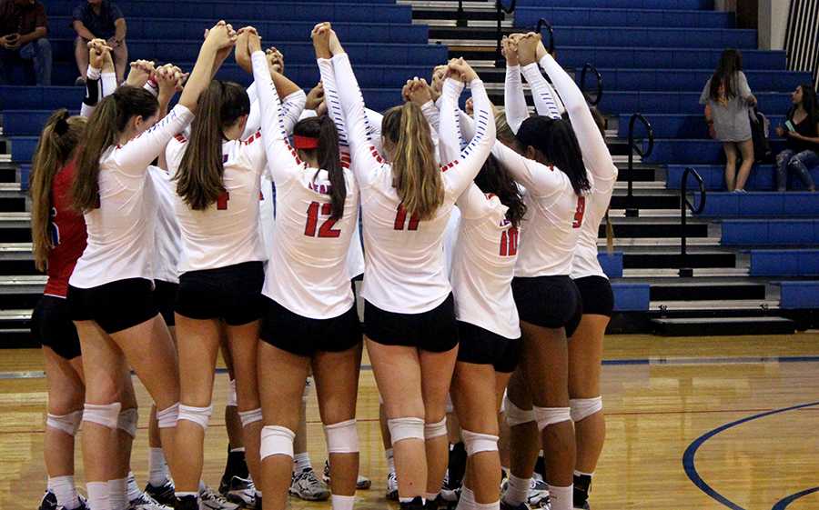 The varsity team talks about what they will do as they huddle together before beginning the first set of the game. This is a tradition that the team carries.