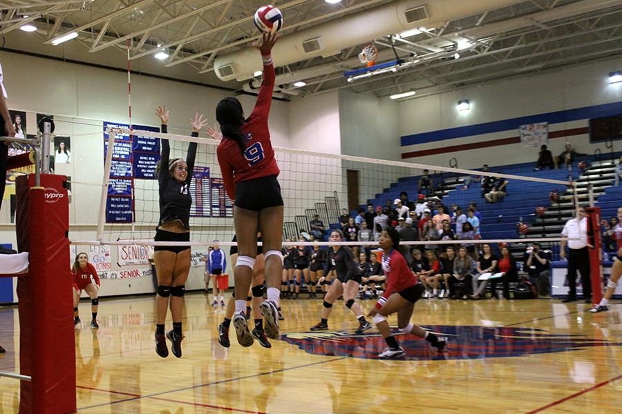 Junior Busi Banda and sophomore Lesley Hall playing Lake Travis. Busi is outside hitter, and Hall is middle blocker.