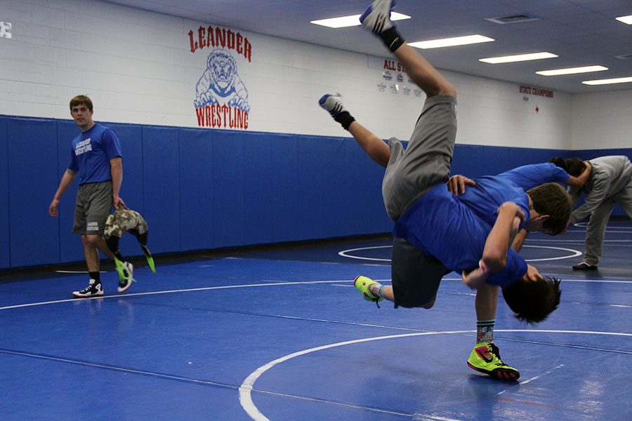 Sophomore John Geiger practices with another wrestler during the wrestling period. The Lions wrestled to third place in their first tournament.