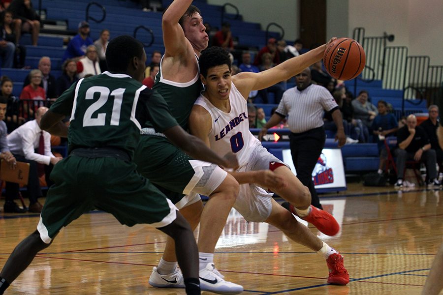 In a previous game, senior Kobe Thompson falls into an opposing player. Thompson plays guard, point guard, and forward for the Lions.