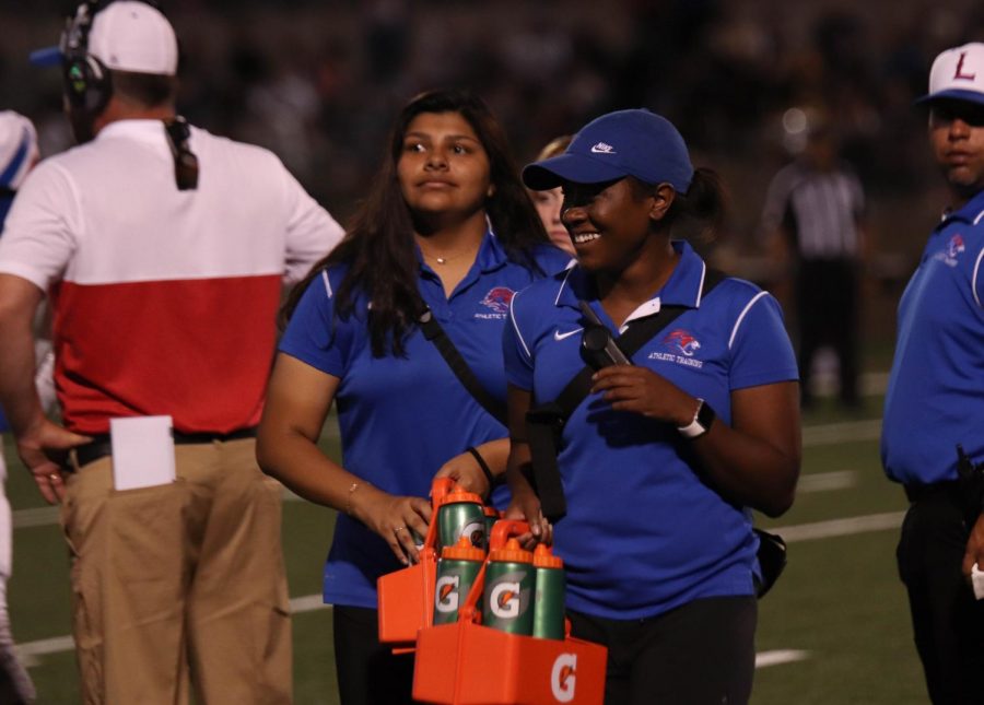 On Aug. 13, athletic trainer Aerin Henderson helps out on the field during a varsity football game against Stony Point.