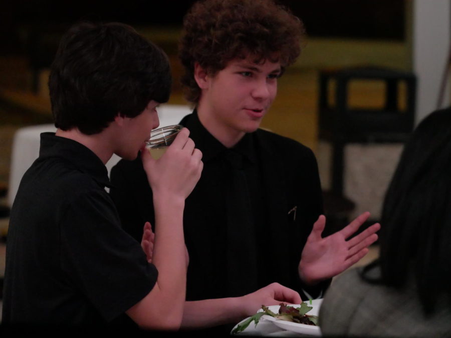 Junior Andrew Crozier as Patrick Finnegan during dinner talking to other cast members and guests.
