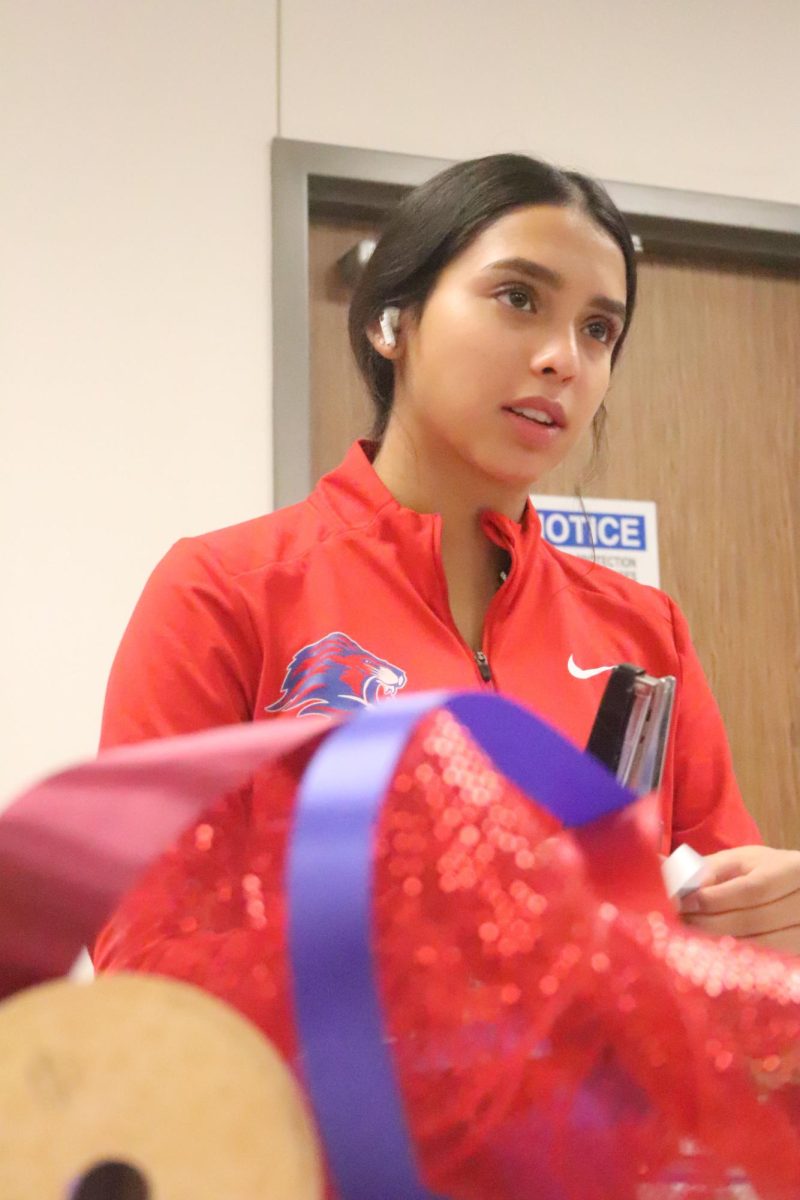 Junior Serra Lumbreras crafts her homecoming mum during Floral Design 1 from ribbon and cardboard; it's a tradition for extravagant mums to be made and worn throughout the Friday before the homecoming game. "I've never made a mum before," Lumbreras  said. "It's very easy if you listen to instructions-- [after that] it's all about creativity. Homecoming is super exciting [because] once the dance is over with we look back on it and think: 'wow we did that.'"