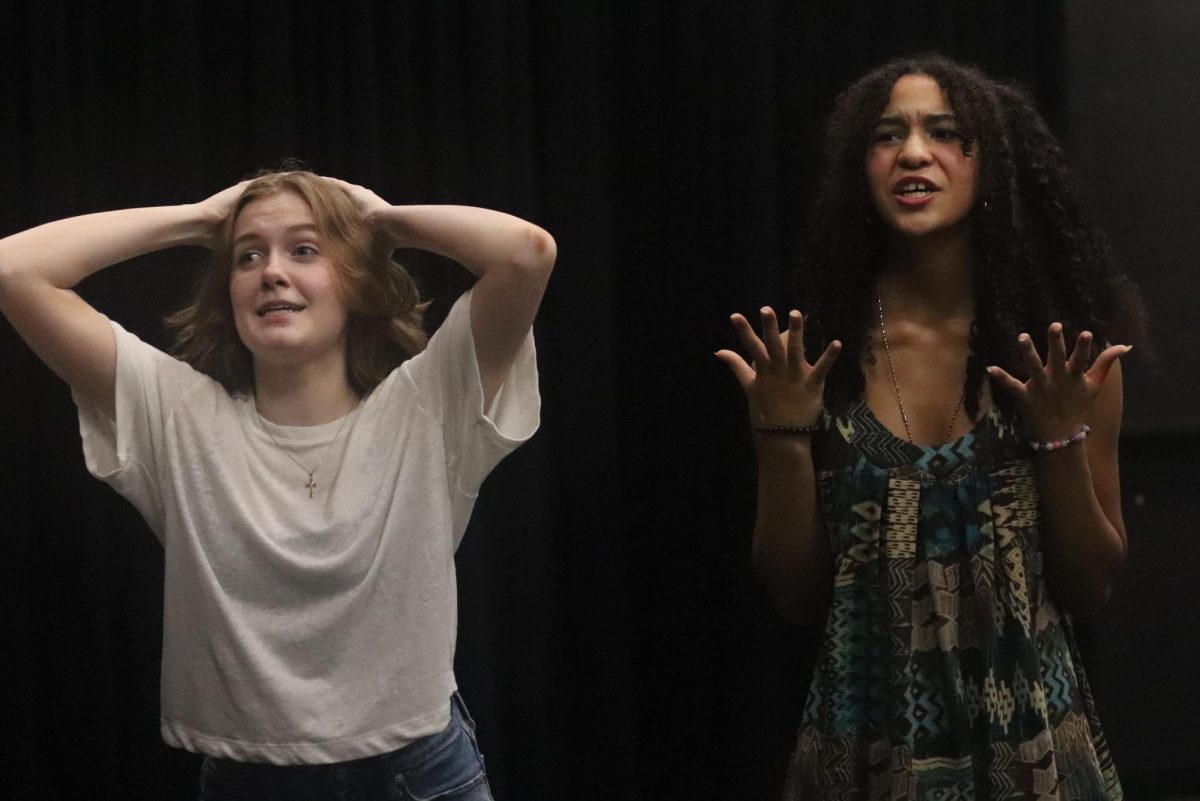 Junior Grace Kennedy and junior Malika Washington participate in theatrical warm-ups during rehearsals for the fall production of the Last Round-Up of the Guacamole Queens. "They bring everyone’s energy up," said Kennedy. "It’s always good to get moving and stretch out your voice”