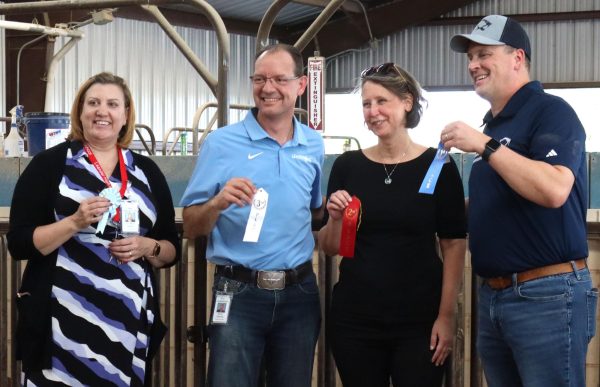 Dean of Instruction Jo Ann Tanzer, Superintendent Bruce Gearing, Board Trustee Trish Bode and Running Brushy Principal Jim Rose pose for a group picture with ribbons of varying degrees. The Agriculture Barn's showing was part of an attempt to publicize the program.