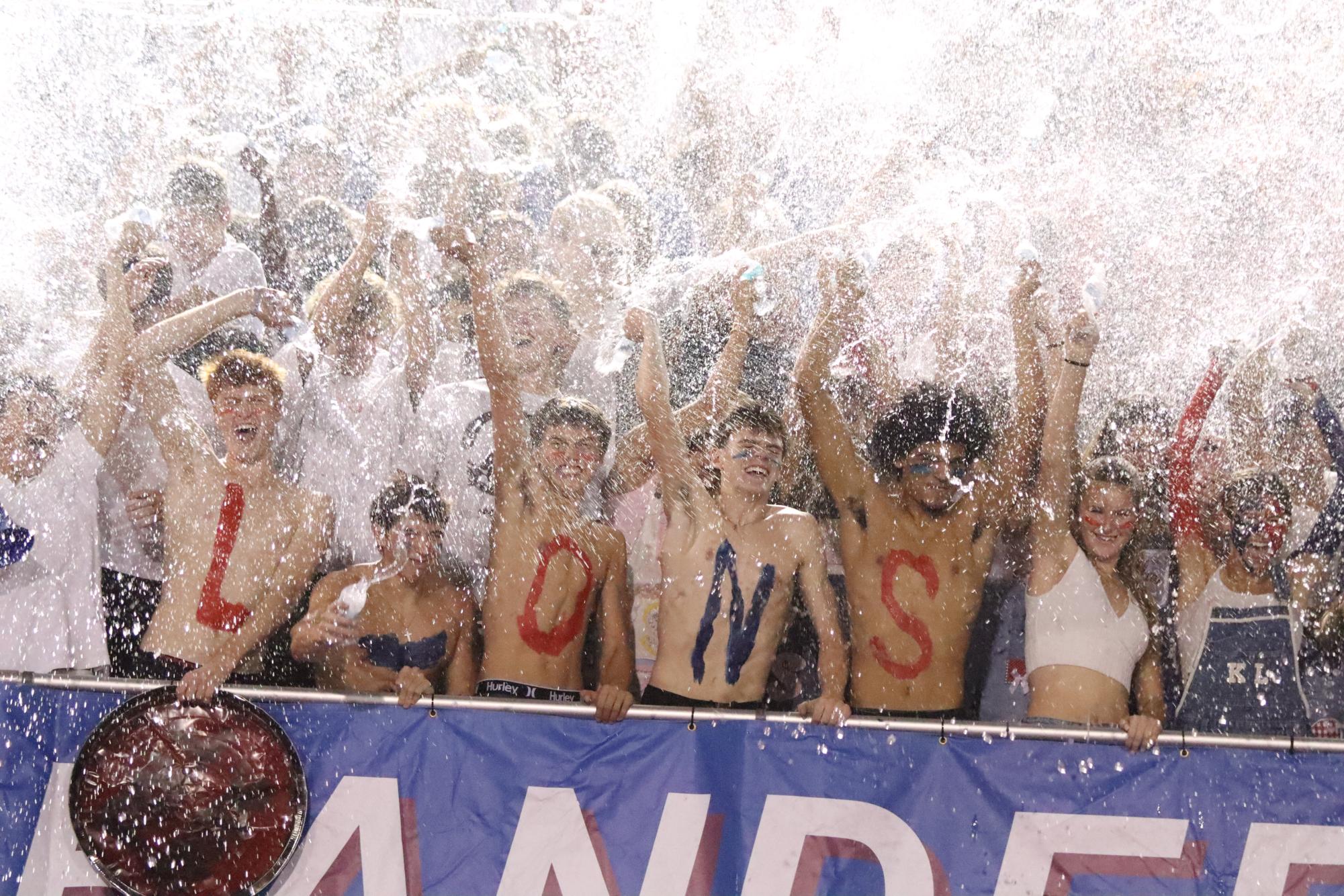 As tradition during every football game, student section fans lift water bottles and soak the crowd.