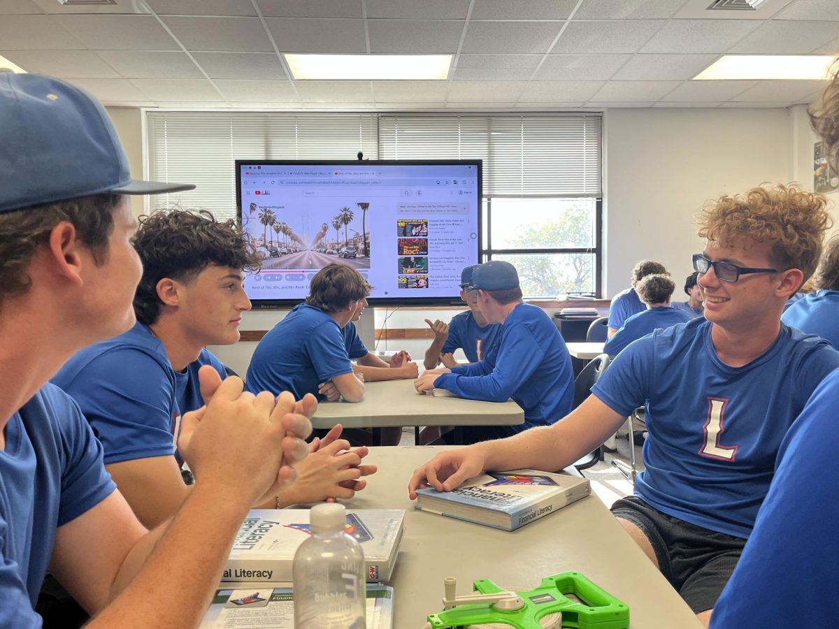 Baseball players outline their game plan for tackling the first day of craft fair set up. All proceeds benefit the team, paying for batting cages, turf, and any sort of additional equipment. 