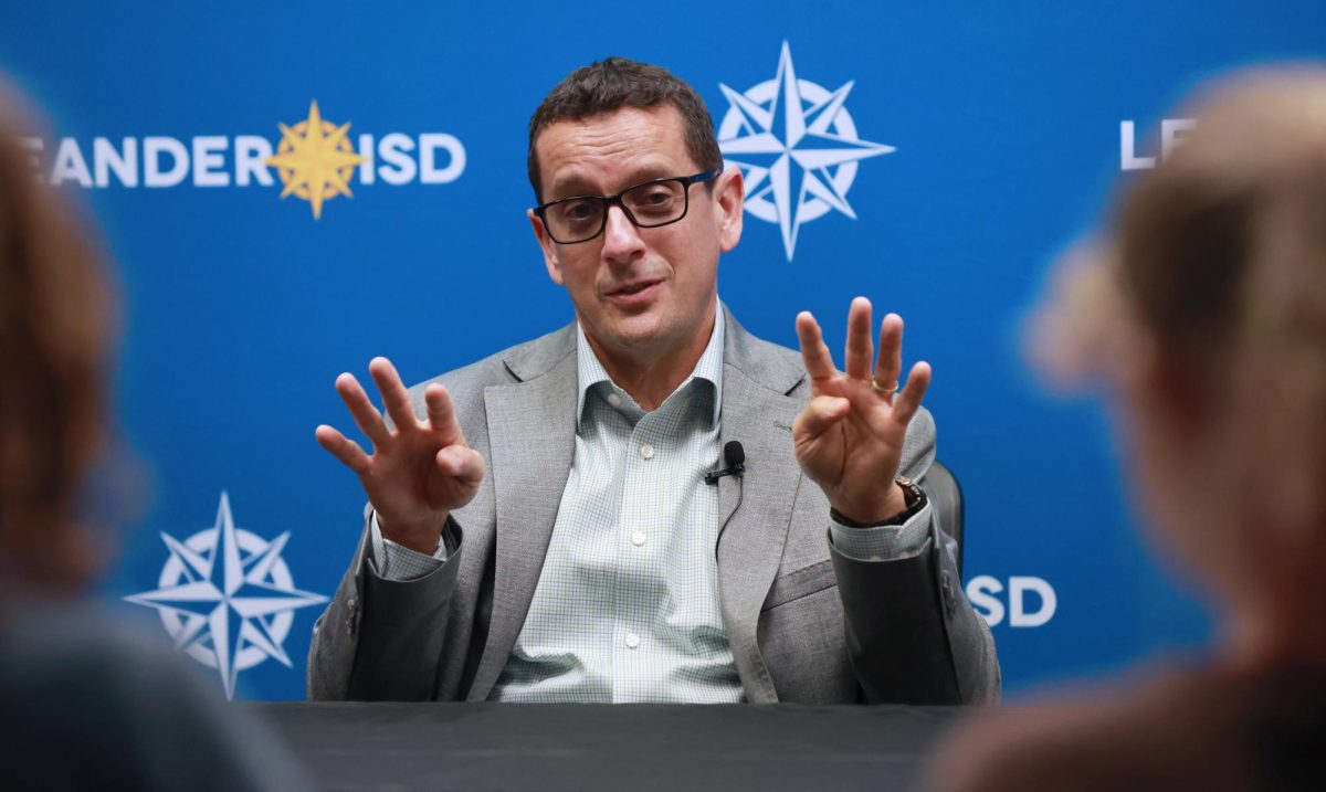Acting Superintendent Chris Clark talks with student reporters Dec. 16. Students from Rouse and Cedar Park High School joined Leander reporters. 