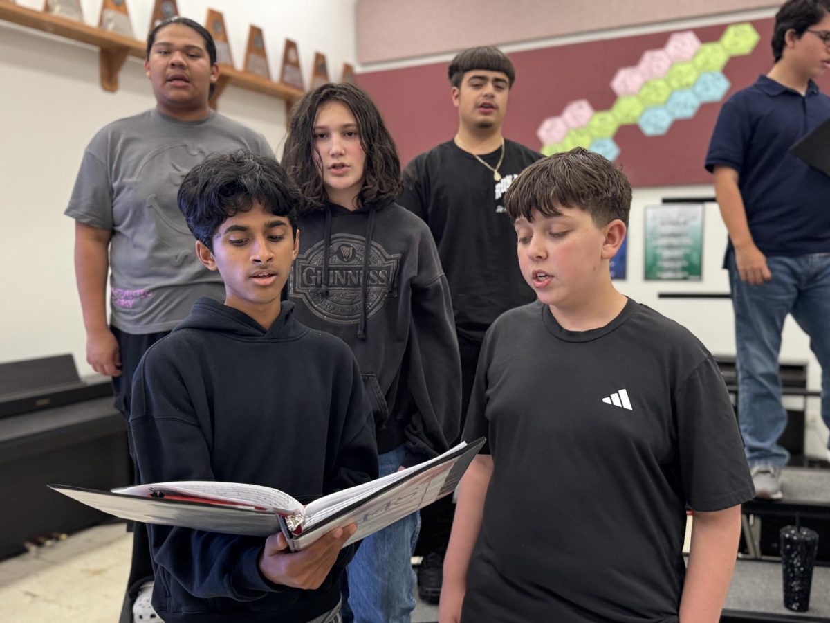 Freshmen Raga Suhih, Reddy and Kottala, and Levi Gordan practice holiday-themed music for the Winter Choir Concert. The choir was directed vocally by choir teacher Christian Clow.