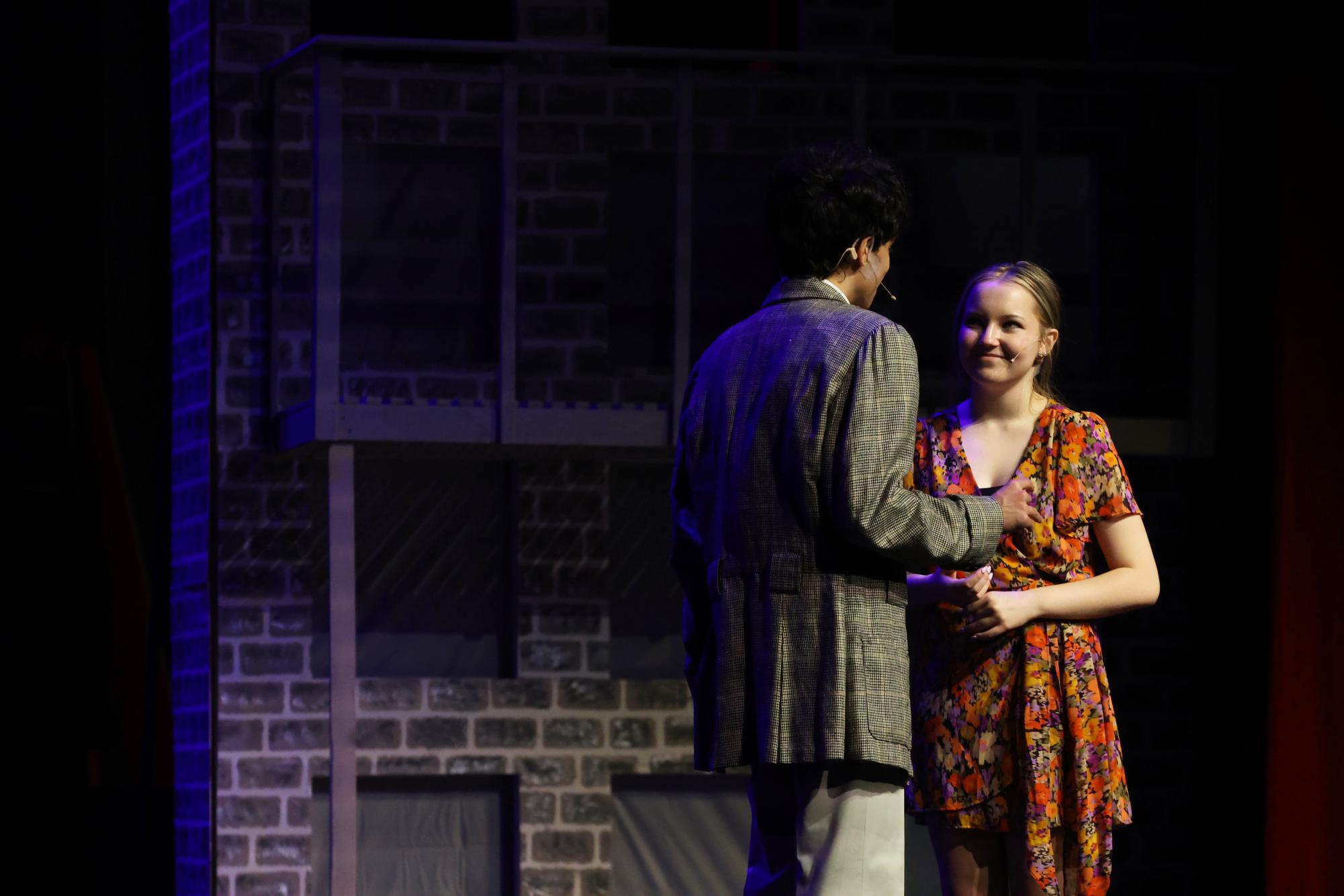 Senior Emma Dezelle cracks a smiles as her cast mate and co-lead, junior Jonas Estrada sings to her during the first dress rehearsal of "Singing in the Rain." 