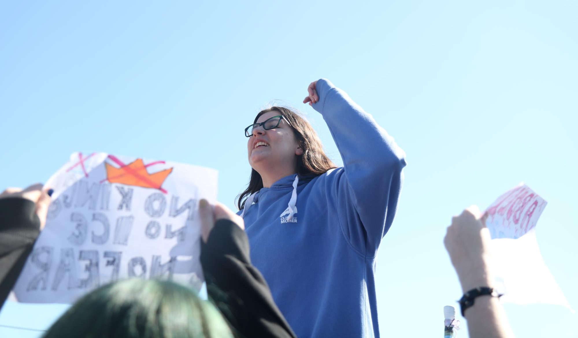 Senior Olivia Baker leads the initial protest in the front of the school. Baker rallied the chants of hundreds of students, filling the parking lot with a chorus of "ICE out!".