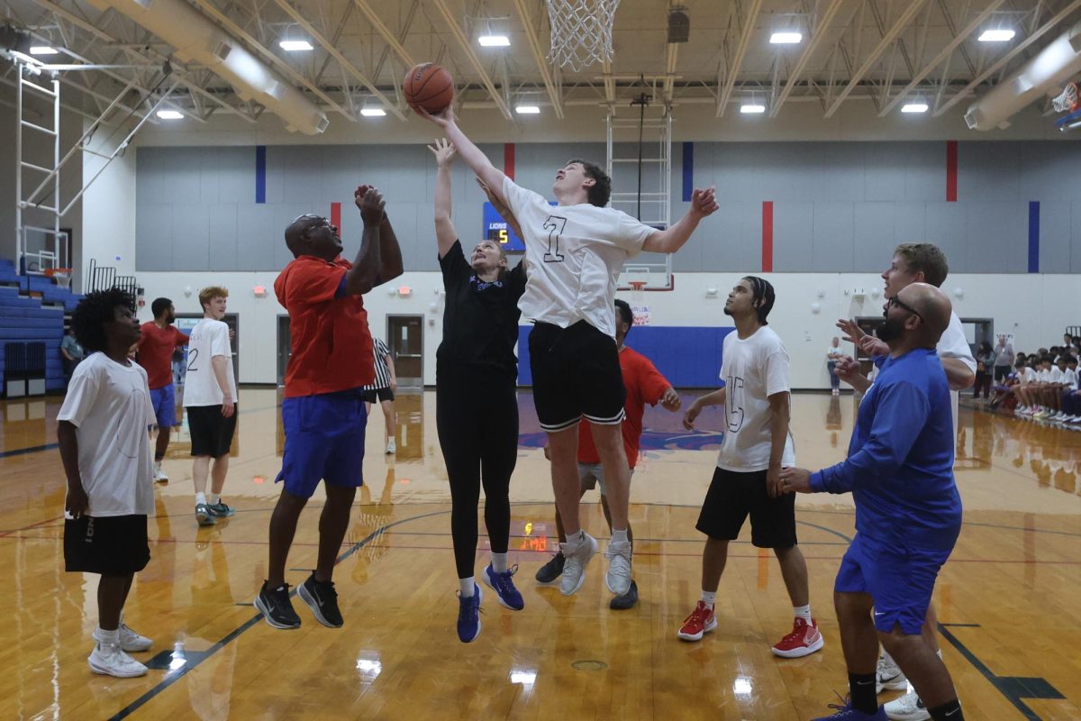 Students and coaches jumping after the ball at the faculty v. student basketball game April 2.