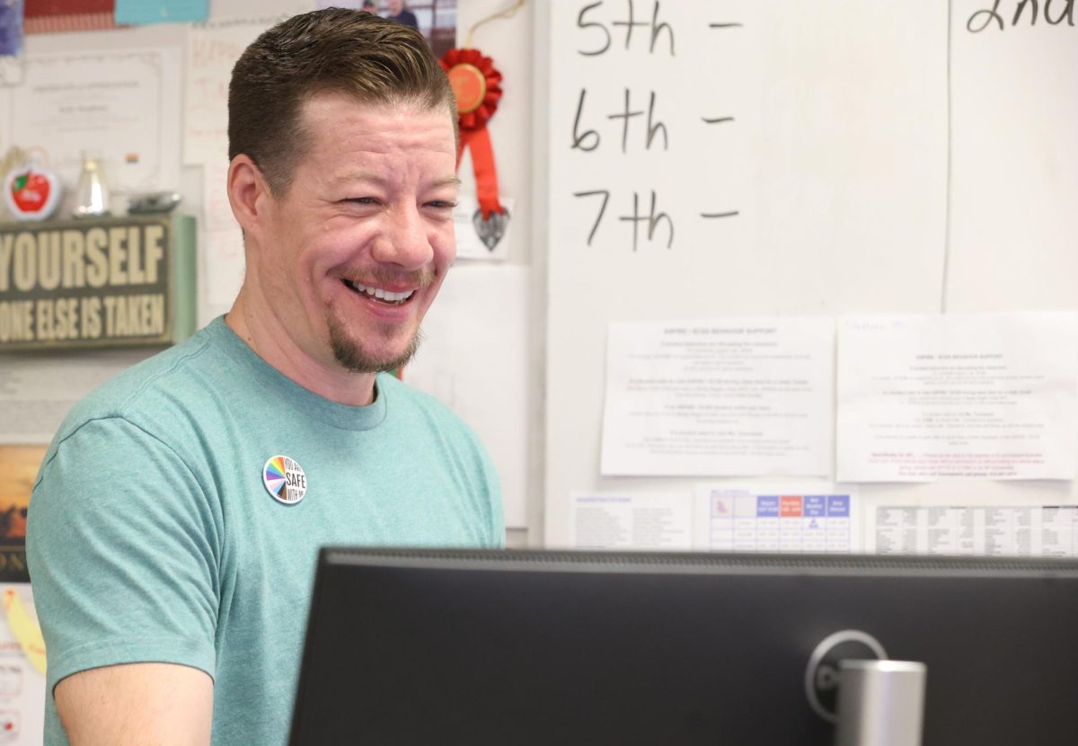 Chemistry teacher Kelly Stephens laughing with his students as he puts in grades April 23. 