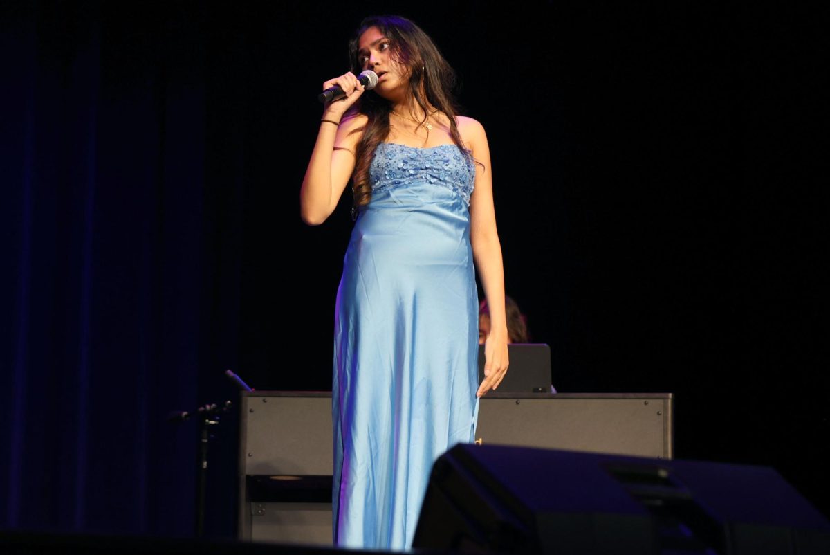 Senior Srinija Chukkapalli sings during her band performance at the annual National Honor Society talent show on the PAC stage April 2. Chukkapalli shared sang a duet with senior Elliana Reed, backed by her in-school band, Xavier's Shirts. “I’m not just English-inclined, but also I'm very creatively inclined too,” Chukapalli said. “I’m always trying to express myself through different types of art. I've always been that way and I have loved reading ever since I was a kid, so literature has been a big influence on my musical journey.”
