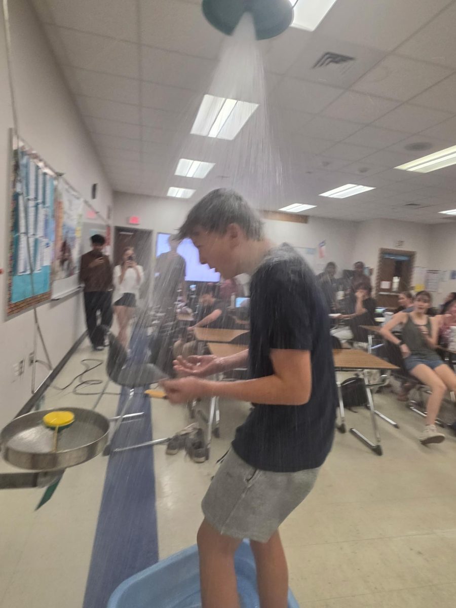 Sophomore Charles Palm ducks in the safety shower in Room 2005 during third period advanced chemistry May 21.