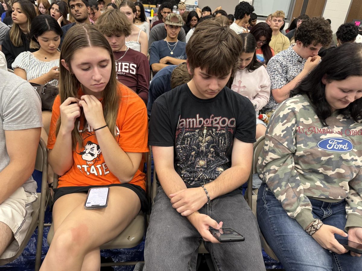 Chloe Michalk and Ronin Miklos wait for their names to be called during graduation practice Thursday morning.