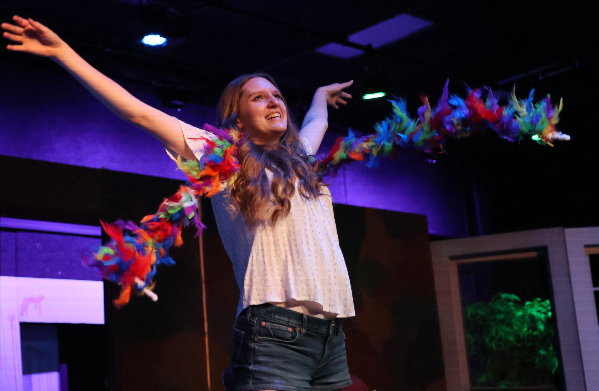 Sophomore Paige Newman throws her feather boa in the air. 