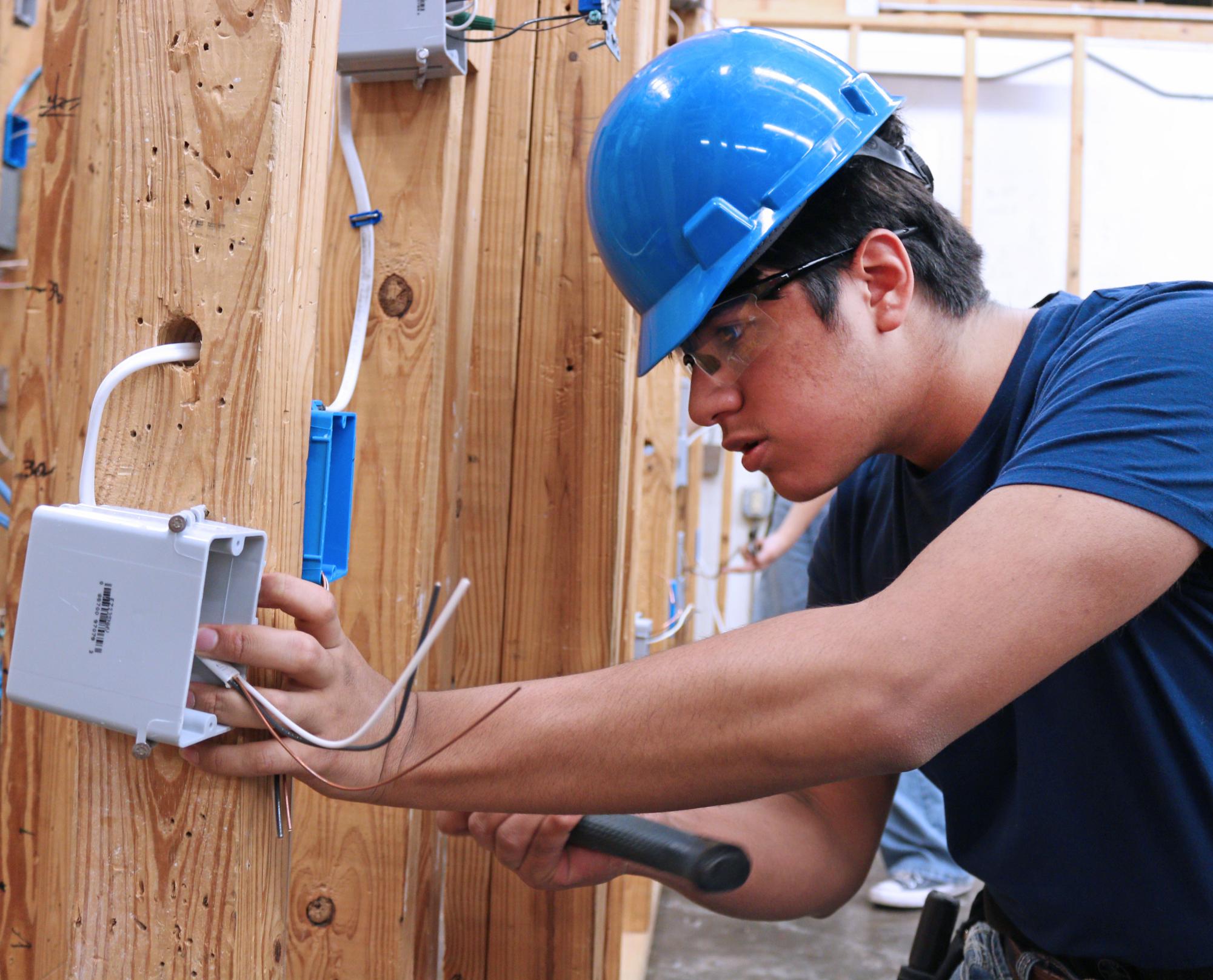 Sophomore Enrique Flores works on wiring assignment sheltered from light rain in first-period electrical class on April 29. “Losing time is always a struggle but it’s one we’ll have to be familiar with before we enter the real world. Electrical is a good class, I strongly recommend it, our teacher is very willing to help us and it’s overall just a great environment.”