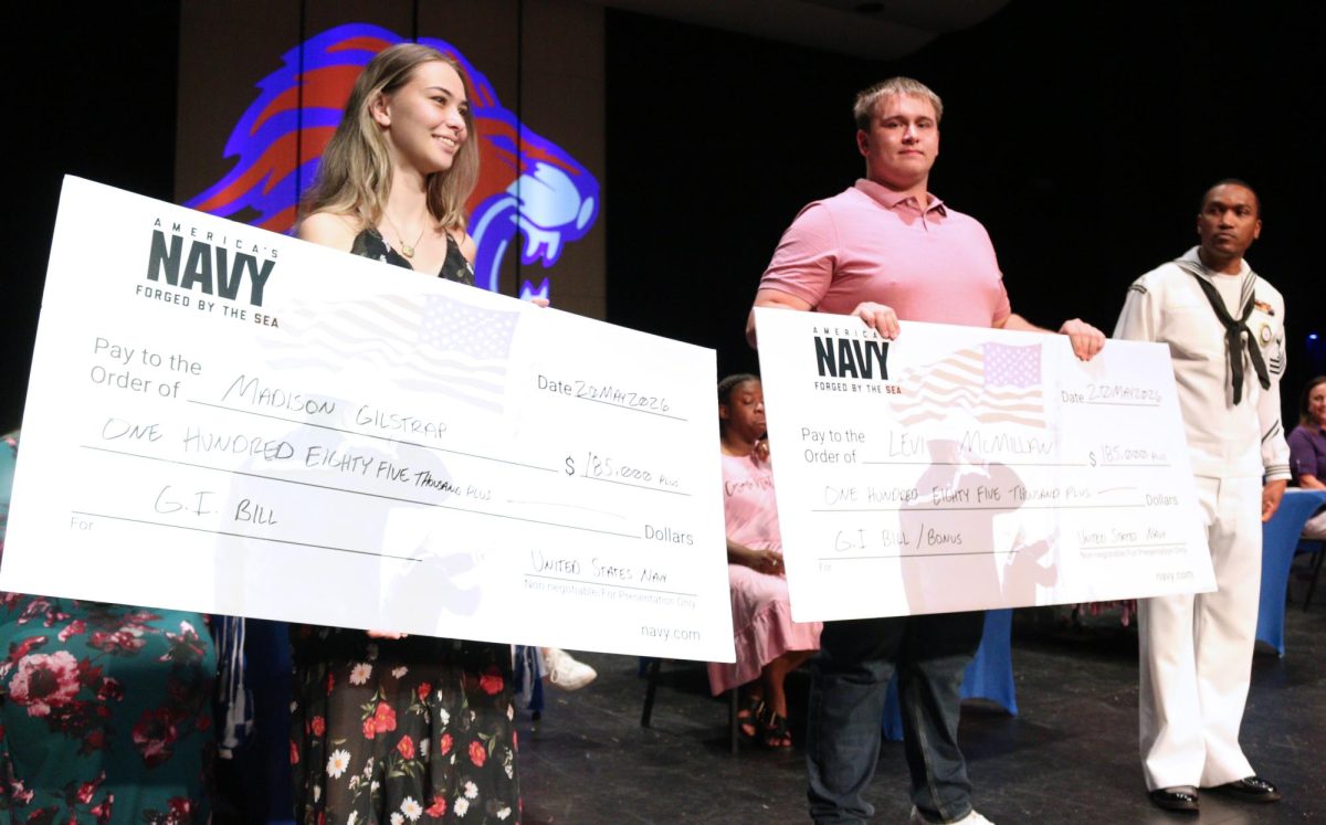 Seniors Madison Gilstrap and Levi McMillan receive $185,000 check from the U.S. Navy at senior awards ceremony in the performing arts center May 20.