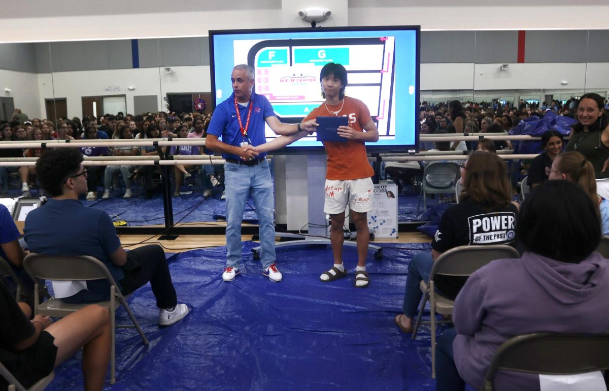 Principal Chris Simpson instructs seniors on the proper method for a handshake at graduation practice May 28. 