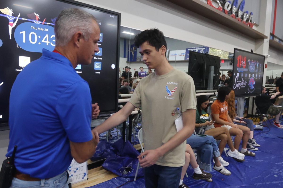 At 10:43 Evan Gonzaga practices handshaking with Principal Chris Simpson. Graduation practice started at approximately 9 a.m. 