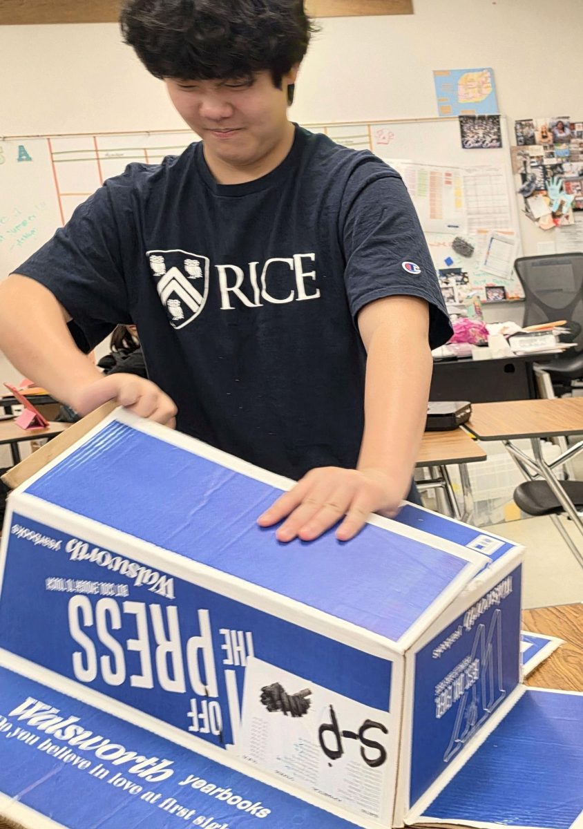 Junior Jaiden Kim breaks down boxes in preparation for "Kiss" a Senior Goodbye, taken May 27.