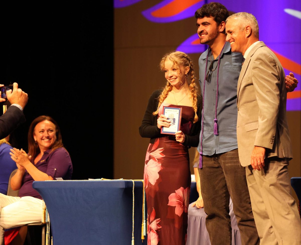 Senior Sophia Clapp and sneior William Wells pose with Principal Chris Simpson as yearbook adviser Bradley Wilson takes a photo. The students had to go through two rounds of voting by teachers and faculty May 20. 