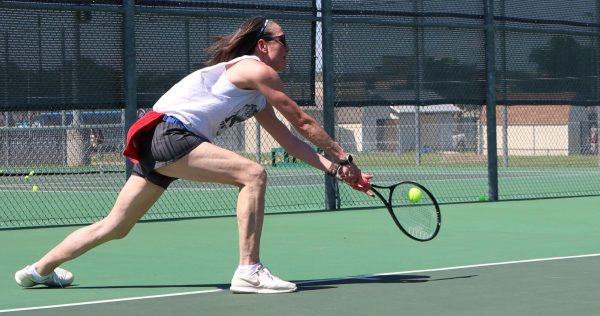 Special Education teacher Michelle Yu lunges down to hit the ball before it hits the ground.